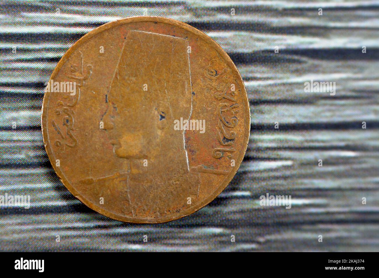Obverse side of an old 1 One Egyptian red millieme year 1950 features Portrait of King Farouk the 1st facing left, wearing fez, the currency of kingdo Stock Photo