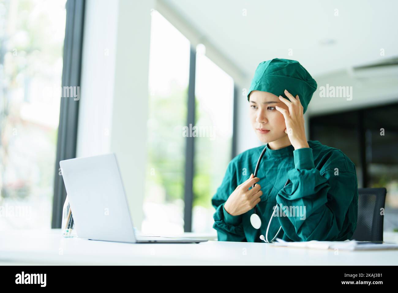 doctor using a computer and showing anxiety over patient information Stock Photo