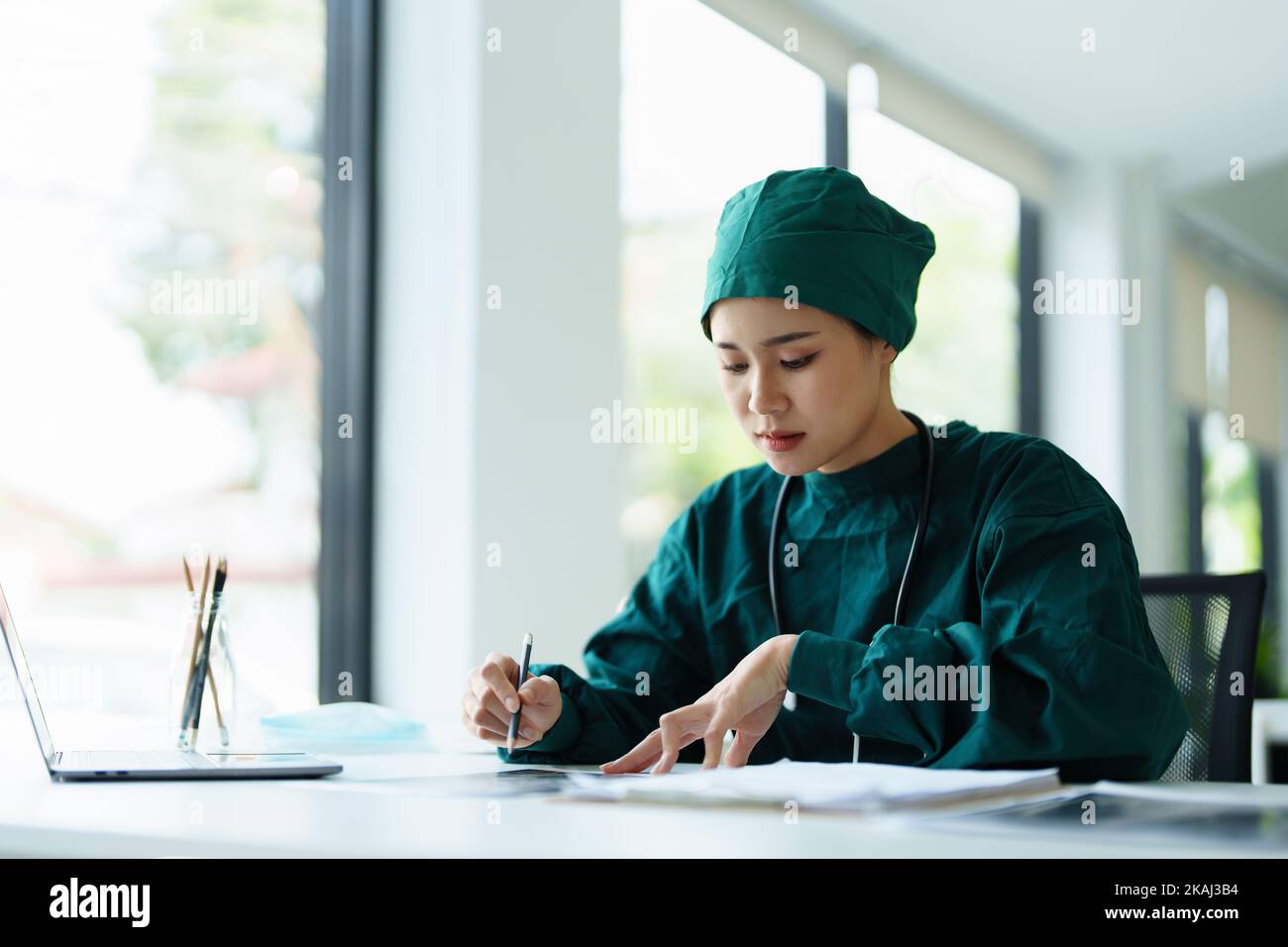 Portrait of an Asian doctor looking at patient X-ray film..Portrait of an Asian doctor looking at patient X-ray film.. Stock Photo