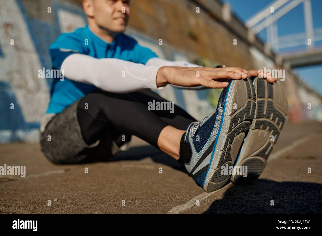 Athletic man doing stretching exercise for leg after of before jogging