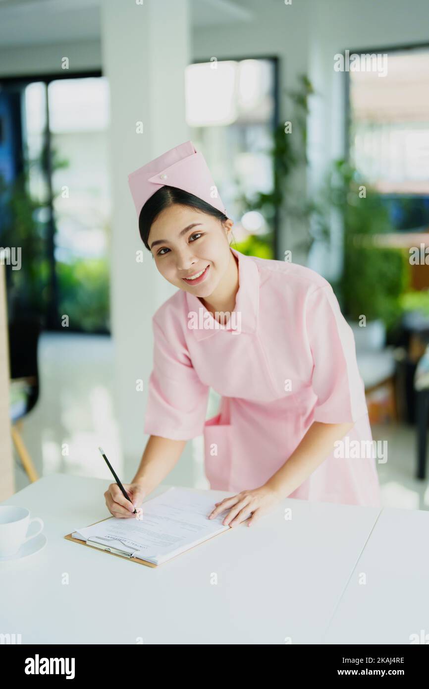 Portrait of a young Asian nurse looking at patient documents Stock Photo