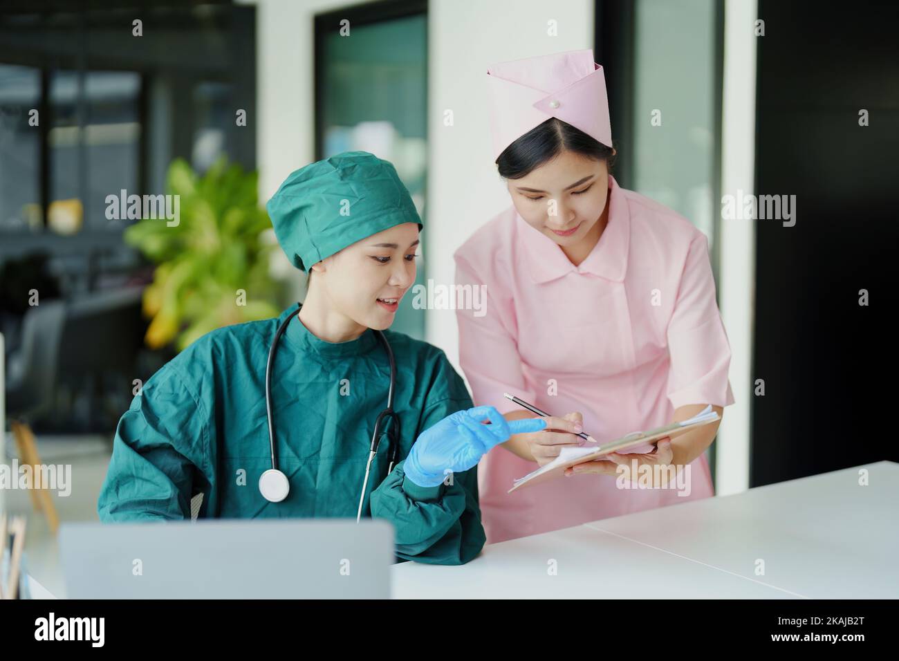 Asian doctors and nurses using computers and documents to view patient