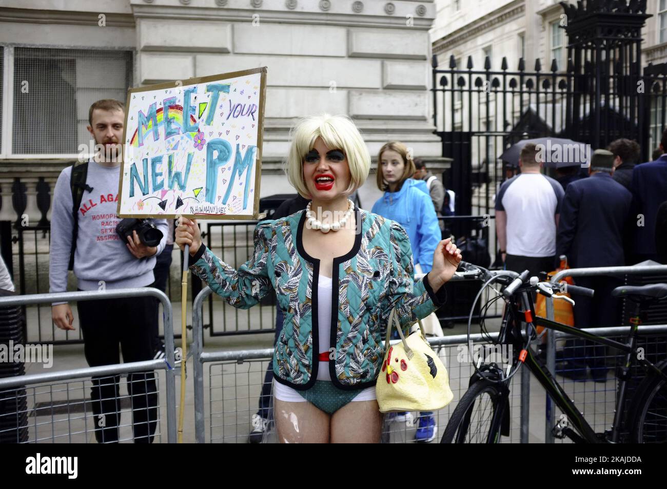 On the day that the new Conservative Party leader Theresa May MP became Prime Minister of the UK, protesters humorously dressed up in face masks and singing amusing political songs mocking the PM outside Downing Street on 13th July 2016 in London, England United Kingdom. The leader of the protest dressed up as a joke Theresa May with blonde wig, crudely put on make up, see through plastic dress and wearing pearls, delighted passers by. (Photo by Jay Shaw Baker/NurPhoto) *** Please Use Credit from Credit Field *** Stock Photo