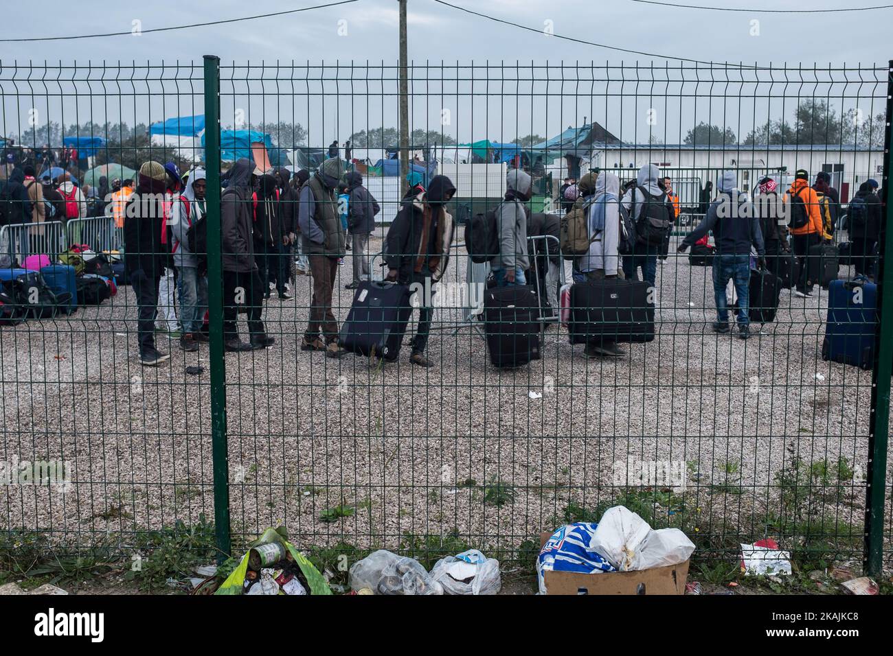 Migrants stand in the official part of the Calais Jungle in a line to leave the camp. The refugee camp on the coast to the English Channel is to be cleared today. The approximately 8,000 refugees are distributed after the registration by busses to various reception centers in France. (Photo by Markus Heine/NurPhoto) *** Please Use Credit from Credit Field *** Stock Photo