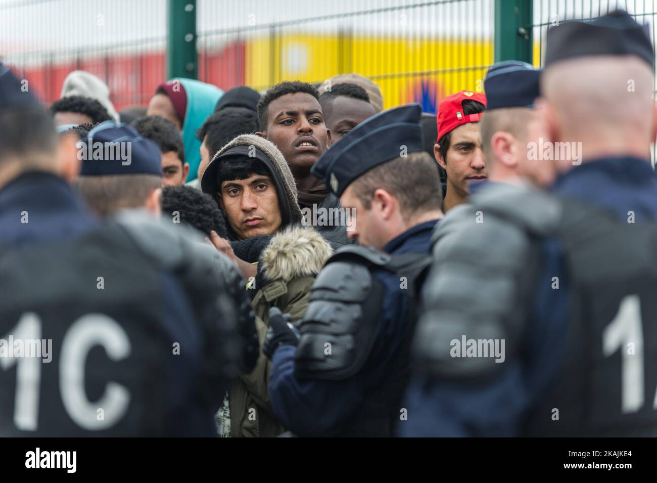 Migrants stand in a line to register themselves in near the Calais Jungle, on October 24, 2016. After registration, the migrants are distributed on buses. The refugee camp on the coast to the English Channel is to be cleared today. The approximately 8,000 refugees are distributed after the registration by busses to various reception centers in France, on October 24, 2016. (Photo by Markus Heine/NurPhoto) *** Please Use Credit from Credit Field *** Stock Photo