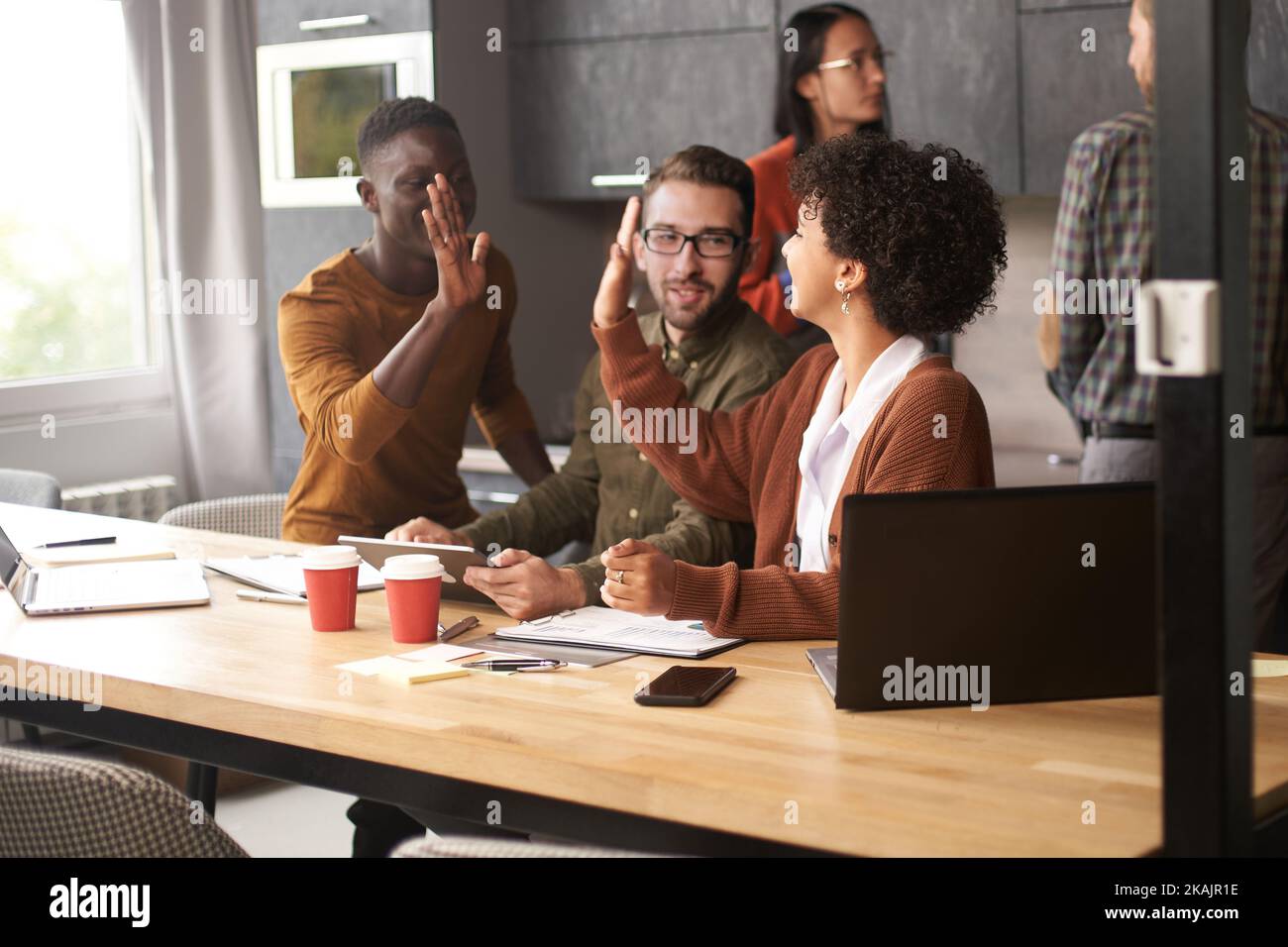 business colleagues giving each other a high five. Stock Photo