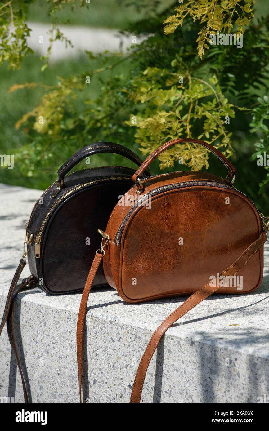 Two small leather bags, dark and light brown colored. round old-fashioned leather bags. outdoors photo. Stock Photo