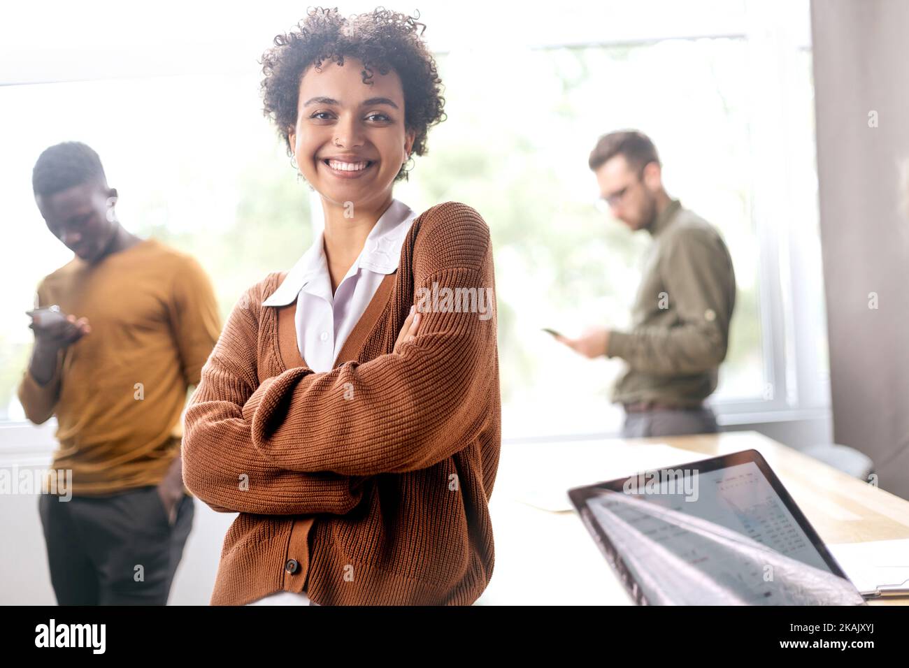 young entrepreneur standing near a desktop in a coworking center . Stock Photo