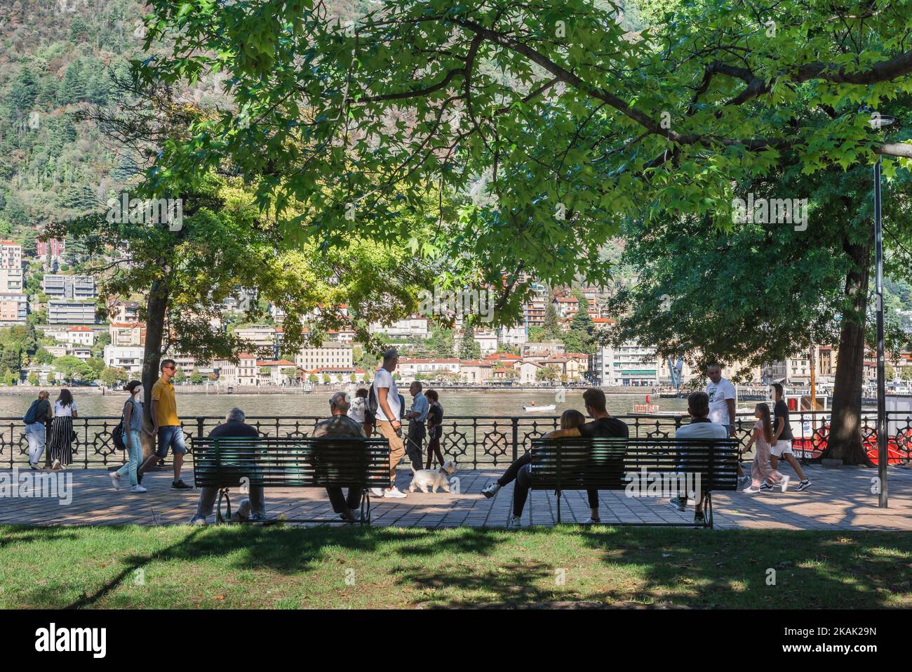 Park people summer, view of people in the Giardini del Tempiano Voltiano enjoying a sunny afternoon beside Lake Como, city of Como, Lombardy, Italy Stock Photo