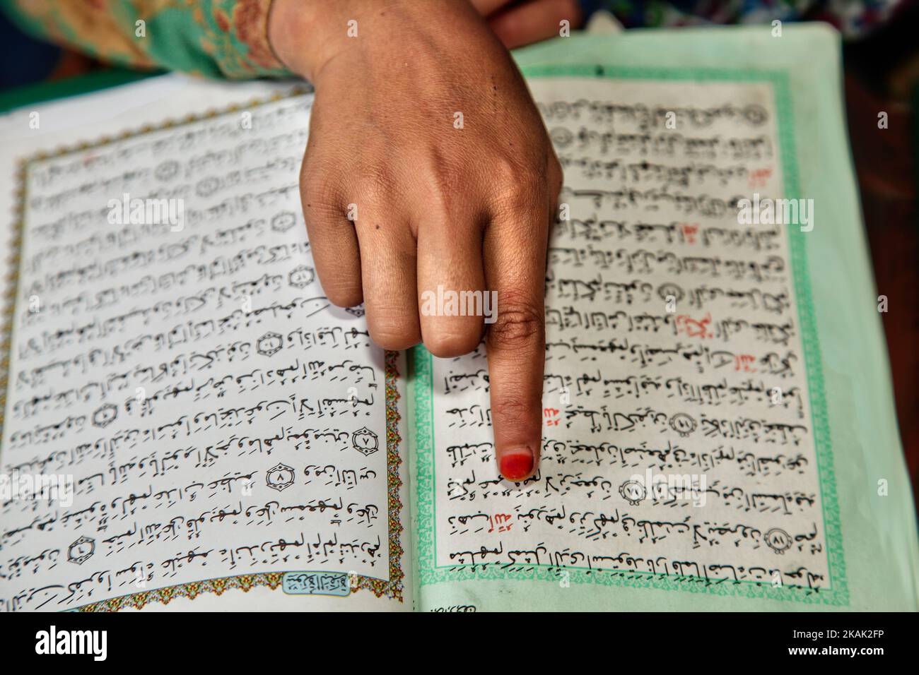 Close-up of the hand of a Muslim girl reading from the Quran at a Madrassa (Islamic religious school) in a small village near the town of Kargil in Ladakh, Jammu and Kashmir, India on June 25, 2014. (Photo by Creative Touch Imaging Ltd./NurPhoto) *** Please Use Credit from Credit Field *** Stock Photo