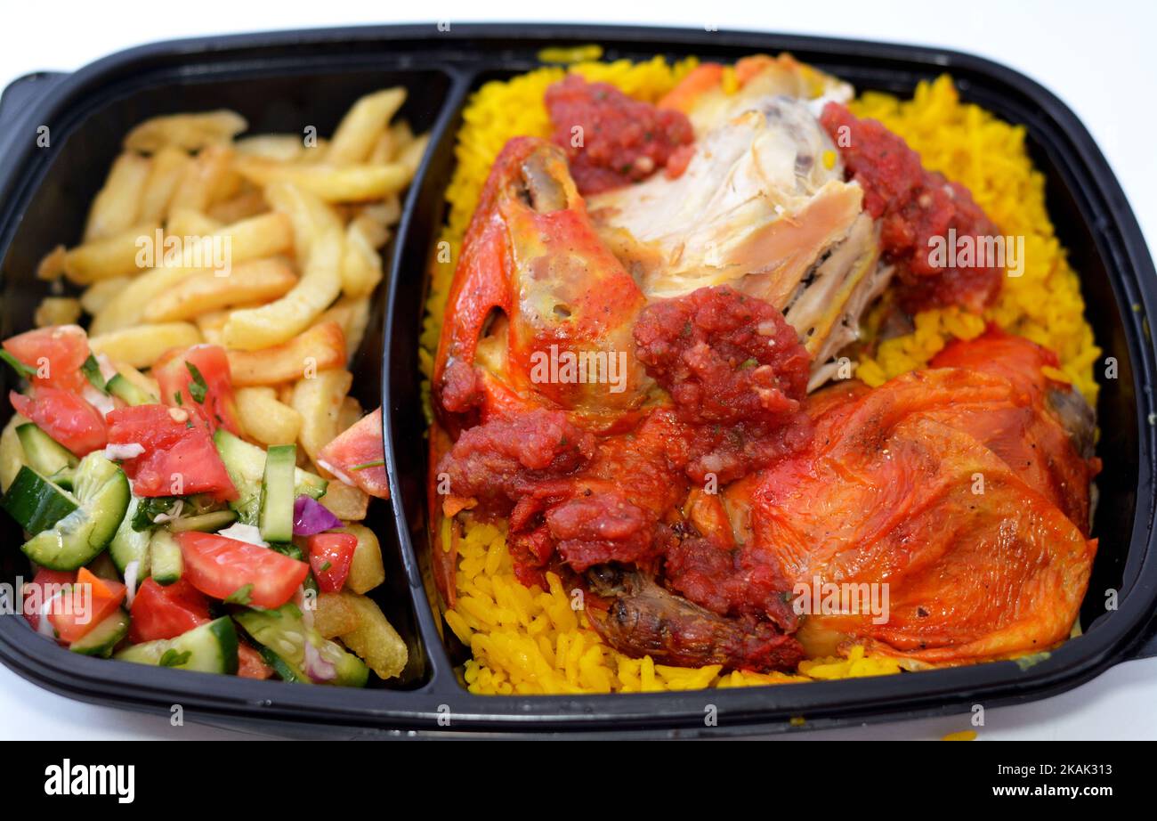 Chicken mandi kabsa with long basmati rice and french fries, served with tomato dakos sauce and green salad, selective focus of Yemen recipe of Mandi Stock Photo