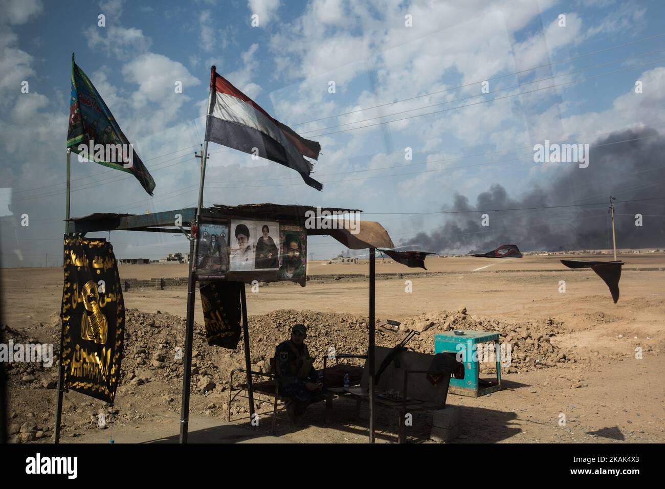 (10/31/2016) On the way to the frontline, 30 km south-west of Mosul, Iraq, the Shia militia 'Hashed al Shaabi' has set up a check point on the street. In the background smoke appear from burning oilfields which ISIS set on fire when they were fought back. (Photo by Sebastian Backhaus/NurPhoto) *** Please Use Credit from Credit Field *** Stock Photo