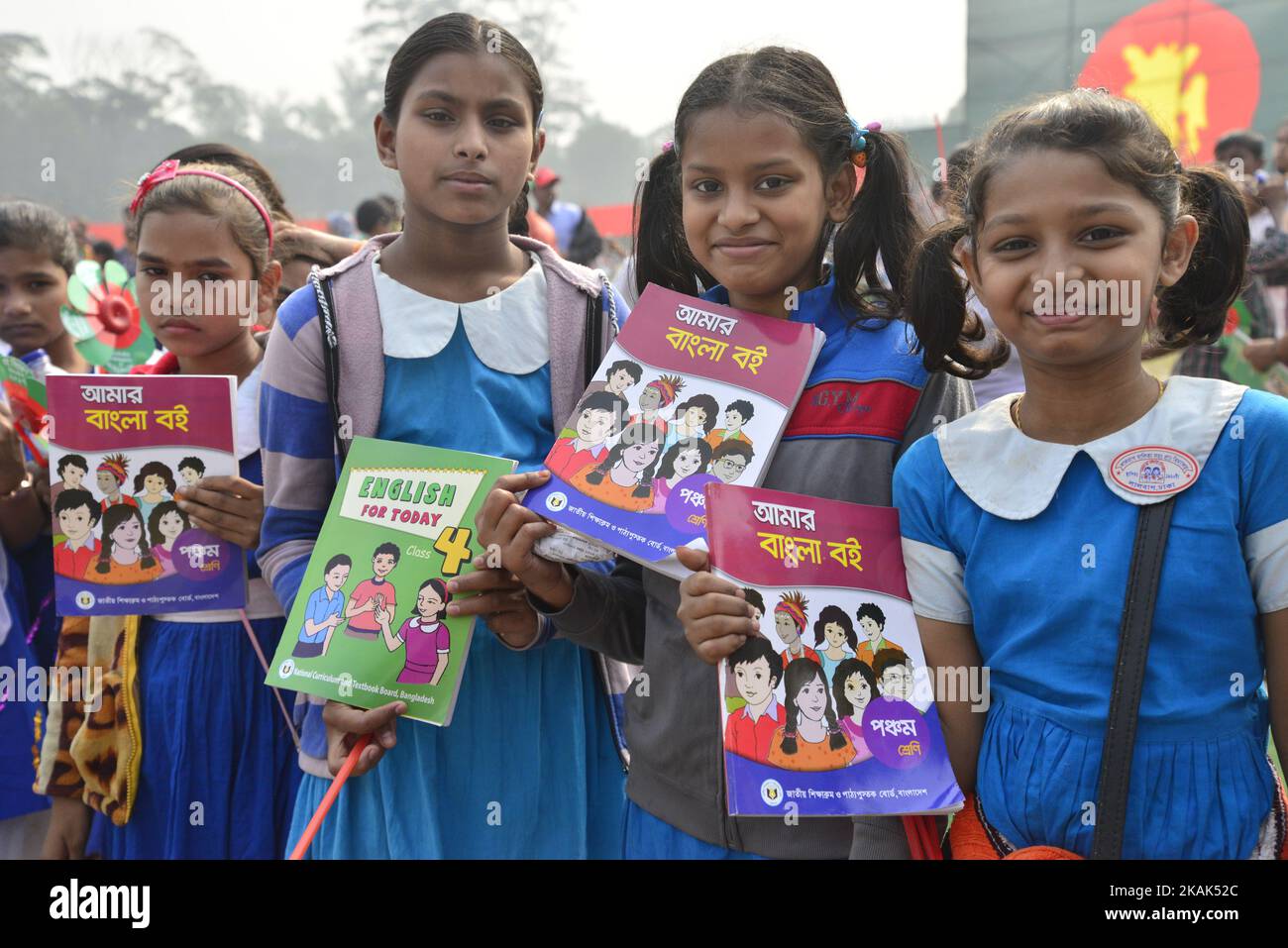 Bangladeshi School students rise up textbook during the Textbook