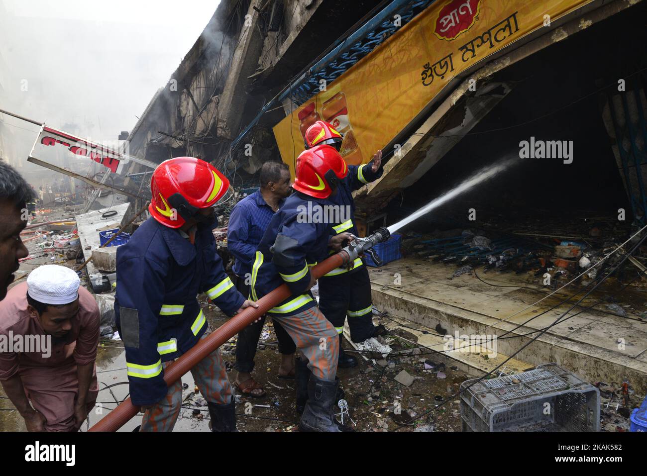 Bangladeshi firefighters try to douse flame after a fire broke out in a ...