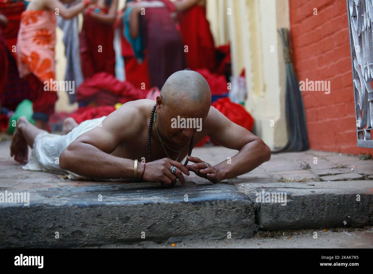 Nepalese Hindu devotee rolls on the ground as a part of ritual after taking holy bath in the Saali River during the Swasthani Barta katha festival at Sankhu in Kathmandu, Nepal, Jan. 12, 2017. Nepalese Hindu women observe a fast and pray to Goddess Swasthani for longevity of their husbands and family prosperity during the month-long festival. (Photo by Sunil Pradhan/NurPhoto) *** Please Use Credit from Credit Field *** Stock Photo