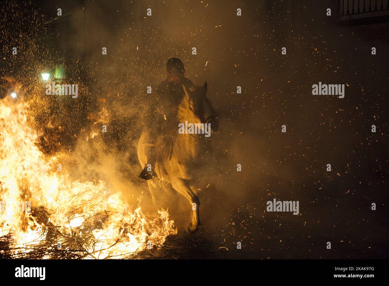 A man rides a horse through a bonfire during 'Las Luminarias' Festival