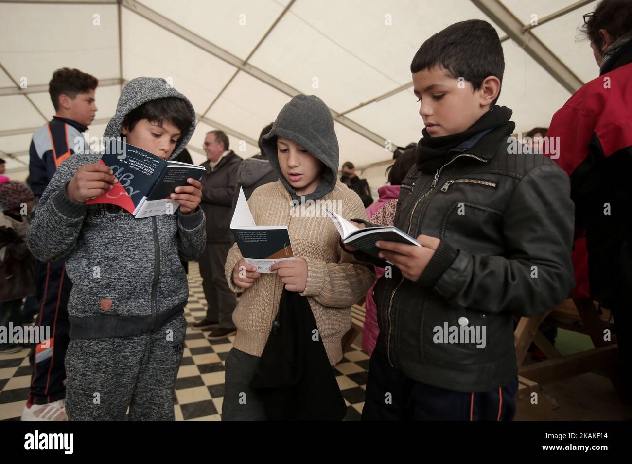 Children look at lexicons given by Greek Migration Minister and the Ambassador of Switzerland in Greece, at the Eleonas camp in Athens, on January 30, 2017. The mini lexicons, in six dialects (Arabic, Farsi, Sorani, French, Kirmantzi, Urdu) with translation in Greek and English, aim to communicate informations to migrants in Greece. (Photo by Panayotis Tzamaros/NurPhoto) *** Please Use Credit from Credit Field *** Stock Photo
