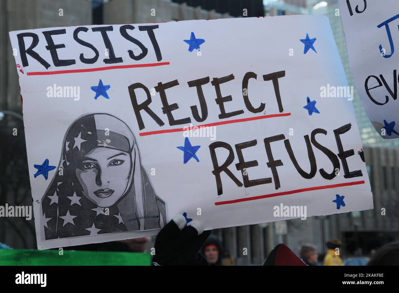 Muslim woman holding a sign saying 'reject, resist, refuse' during a massive protest against President Trump's travel ban outside of the U.S. Consulate in downtown Toronto, Ontario, Canada, on January 30, 2017. Canadians joined countries around the world in protesting against American President Donald Trump's executive order, banning citizens of seven majority Muslim countries (Iran, Iraq, Sudan, Somalia, Syria, Yemen and Libya) from entering the United States for the next three months and banning Syrian refugees from indefinitely entering America. (Photo by Creative Touch Imaging Ltd./NurPhot Stock Photo