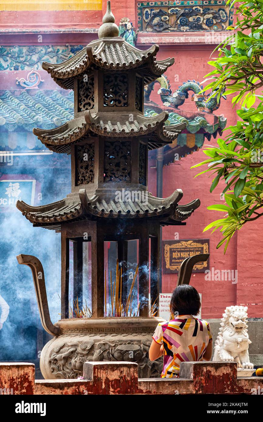 Vietnamese woman offers incense and prays at Jade Empress Pagoda, Ho Chi Minh City, Vietnam Stock Photo