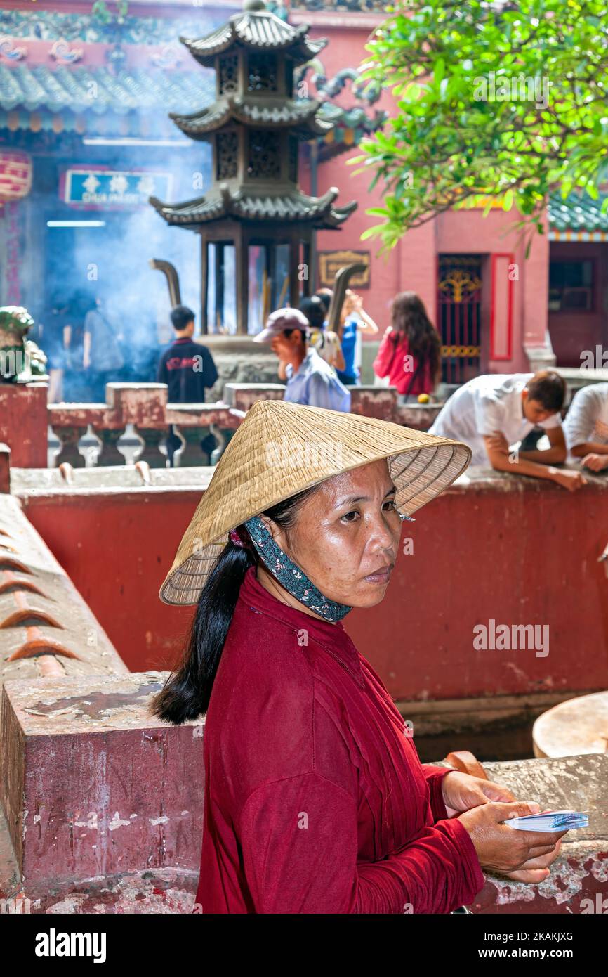 Vietnamese woman wearing bamboo hat in front of Jade Empress Pagoda, Ho Chi Minh City, Vietnam Stock Photo