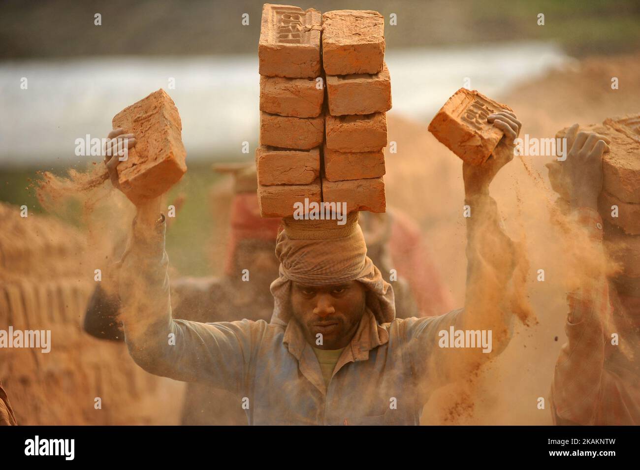A Migrant Indian labourer stacks bricks by balancing them onto his head at a brick factory in Lalitpur, Nepal on Wednesday, February 15, 2017. Indian labourers carrys 12 to 16 bricks on his head. (Photo by Narayan Maharjan/NurPhoto) *** Please Use Credit from Credit Field *** Stock Photo