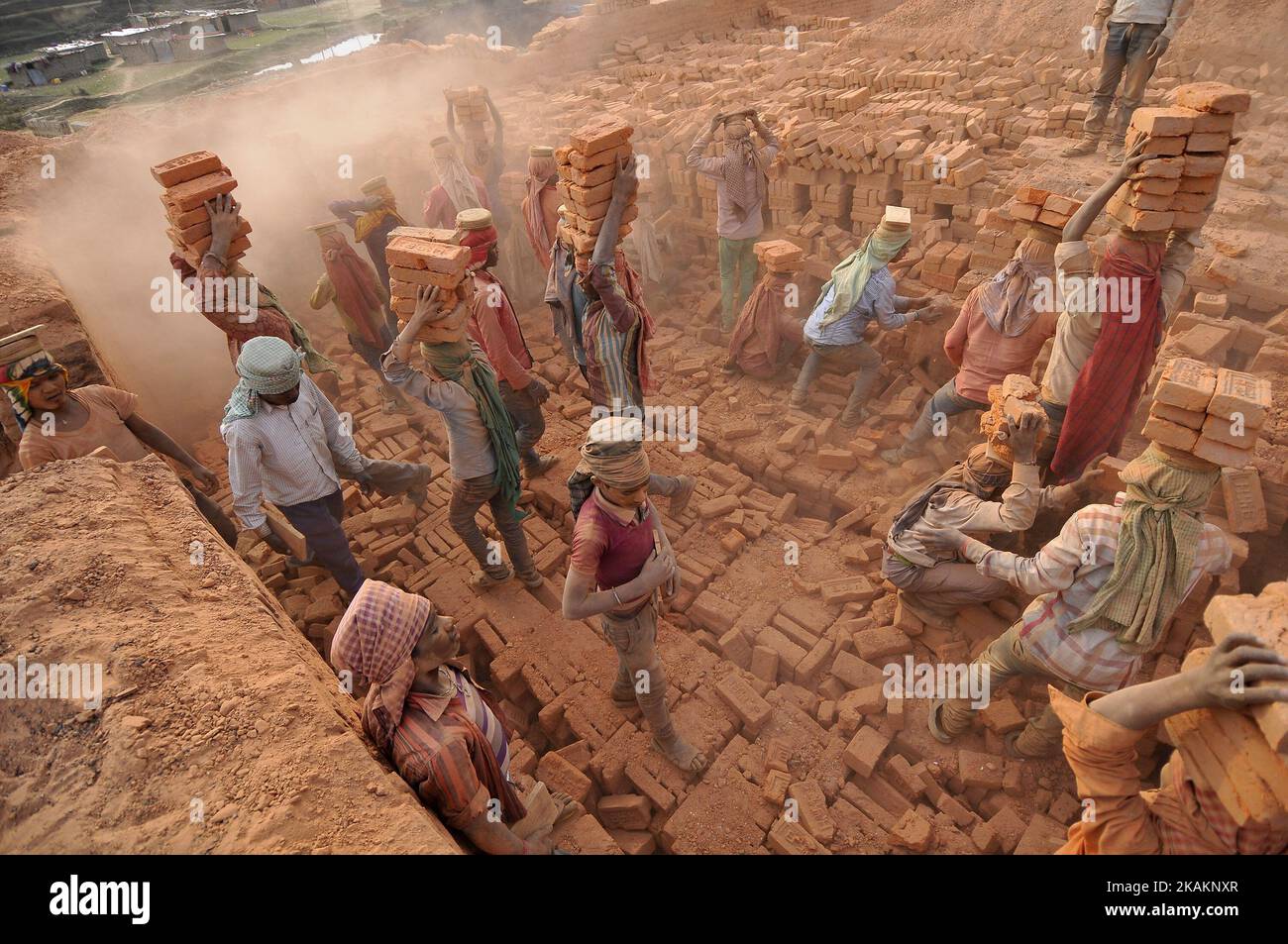 Migrant Indian labourers stacks bricks by balancing them onto his head at a brick factory in Lalitpur, Nepal on Wednesday, February 15, 2017. Indian labourers carrys 12 to 16 bricks on his head. (Photo by Narayan Maharjan/NurPhoto) *** Please Use Credit from Credit Field *** Stock Photo