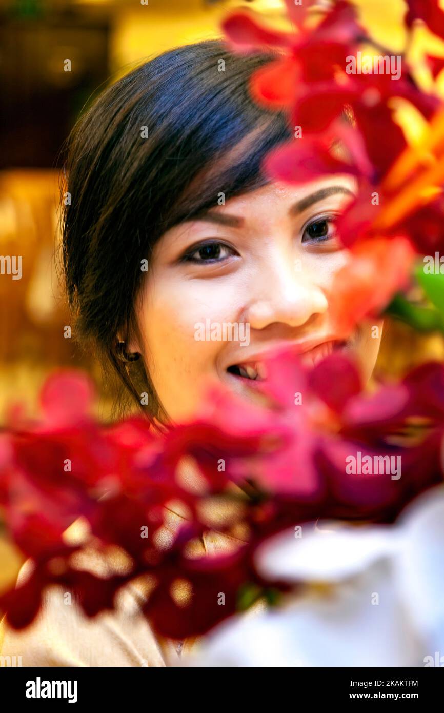 Attractive, Vietnamese, girl, posing, with, flowerss, Ho Chi Minh City, Vietnam, beautiful, young, youth, female, lady, face, expression, smile, happy Stock Photo
