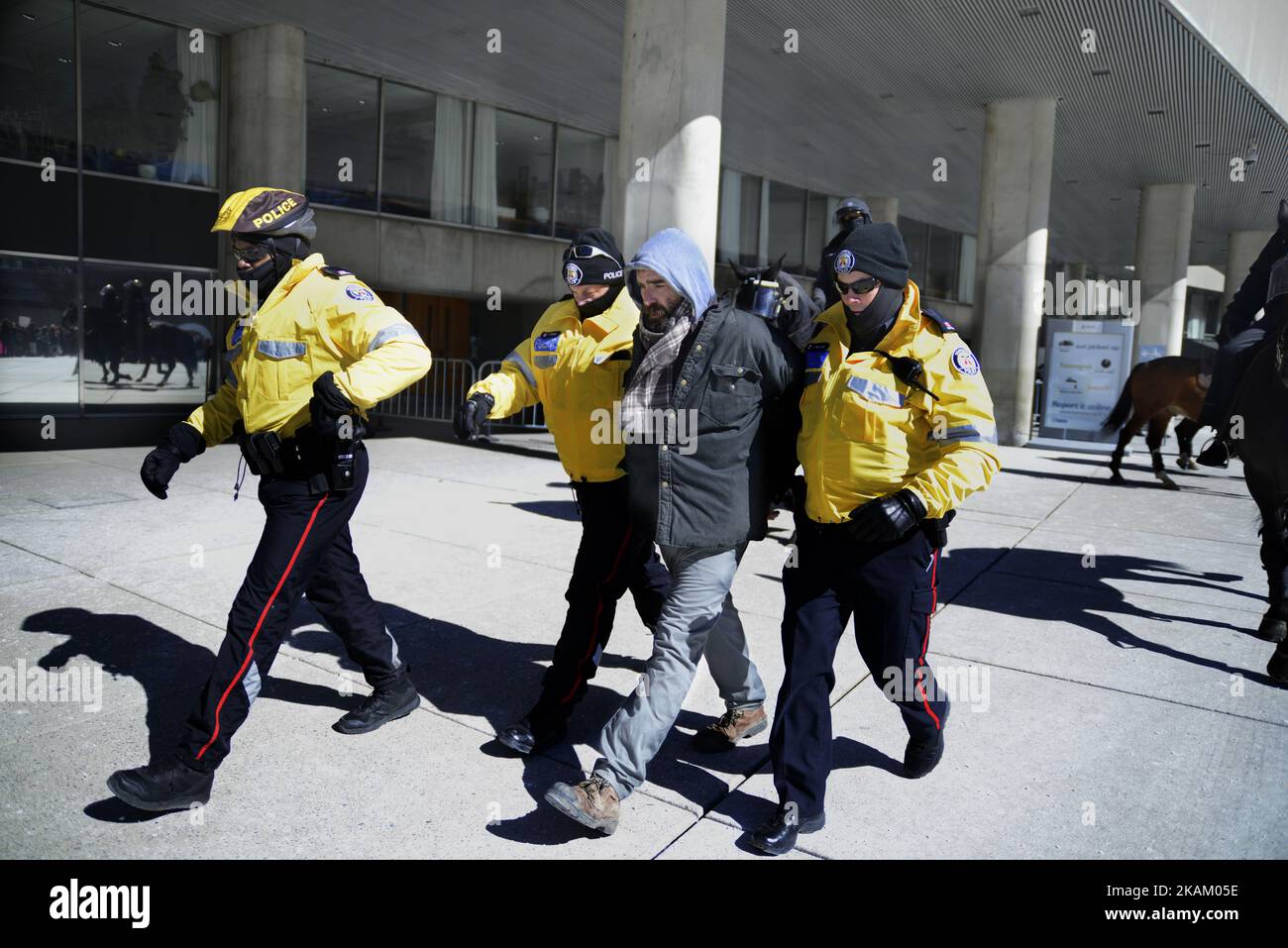 Police walking down a protester after he was arrested during a rally where anti-Muslim and pro- Muslim protesters came together to protest at Nathan Phillips Square in Toronto, Canada, on 4 March 2017. (Photo by Arindam Shivaani/NurPhoto) *** Please Use Credit from Credit Field *** Stock Photo
