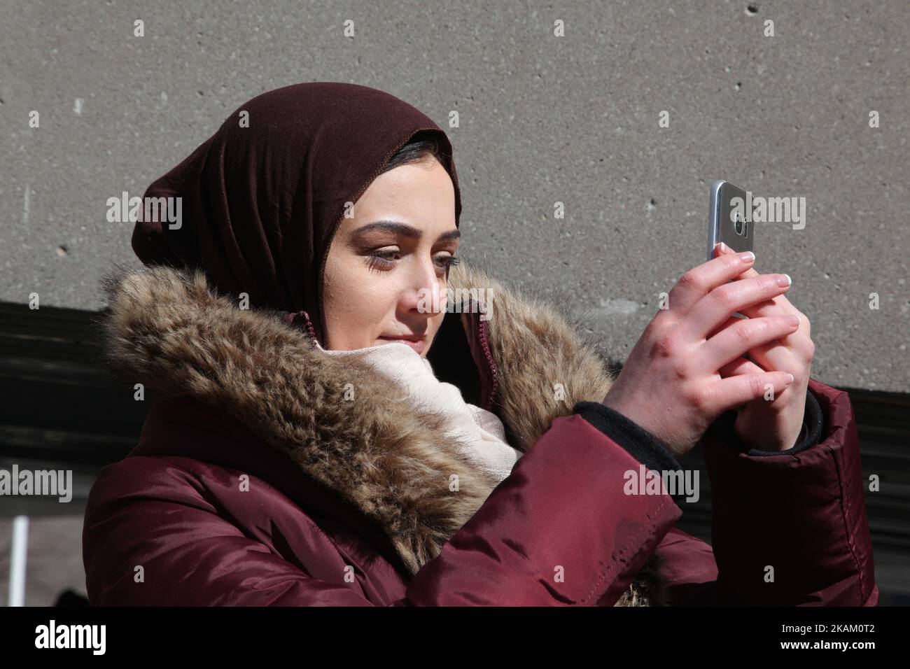 Muslim records a video as anti-Muslim group as protest against Islam, Muslims, Sharia Law and M-103 (private members motion put forth by Liberal MP Iqra Khalid to condemn Islamophobia) in downtown Toronto, Ontario, Canada, on March 04, 2017. Canadians across the country staged similar protests which were met by counter protests by those supporting Muslims and in favour of M-103. M-103 is a private members motion put forth by Liberal MP Iqra Khalid that asks the government to 'recognize the need to quell the increasing public climate of hate and fear' and condemn Islamophobia, as well as all ot Stock Photo
