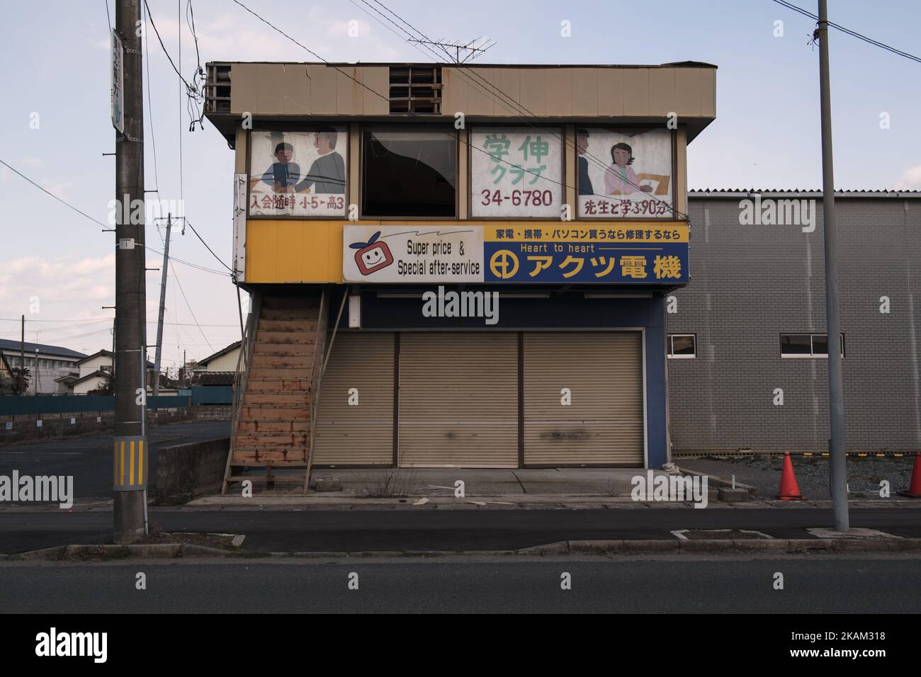 A destroyed computer store and tutoring school left behind in front of Namie station in Fukushima prefecture at 10 March 2017. Six years have passed since the Great East Japan Earthquake and Tsunami disaster on 11 March 2011. Japanese National Police Agency report confirmed 15,893 deaths and 2,556 people missing across twenty prefectures. And 123,618 people are still living in temporary housing away from their home now. The Japanese government plans to lift evacuation orders in heavily contaminated areas around Fukushima Nuclear Power Plant complex by the end of March 2017, except some parts o Stock Photo