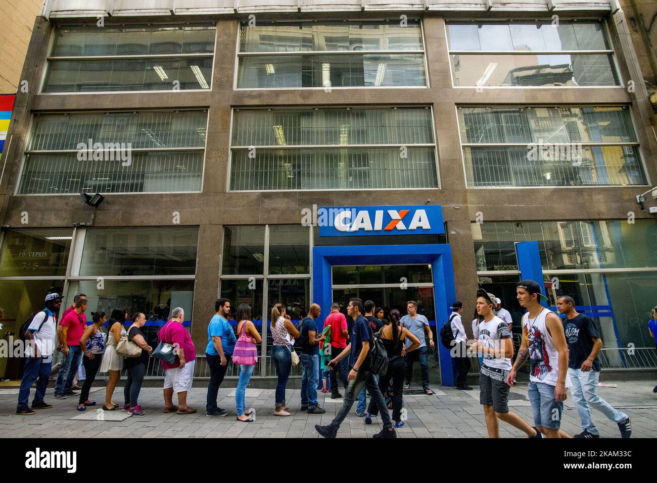 Customers stand in line to speak to an employee about withdrawing money from the Workers Severance Fund (FGTS) outside a Caixa Economica Federal bank branch in Sao Paulo, Brazil, on Friday, March 10, 2017. The Government releases from this Friday the withdrawals of inactive accounts of the Fund for the Guarantee of Time of Service (FGTS) - promised by President Michel Temer in (MP 763/16) is expected to benefit 30.2 million workers and to inject about 30 billion reais into the economy, according to the authorities. The branches of the Federal Savings Bank opened in advance, at 8 am (Brasília t Stock Photo