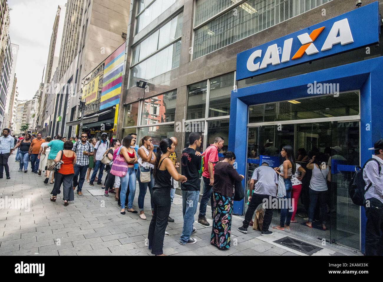 Customers stand in line to speak to an employee about withdrawing money from the Workers Severance Fund (FGTS) outside a Caixa Economica Federal bank branch in Sao Paulo, Brazil, on Friday, March 10, 2017. The Government releases from this Friday the withdrawals of inactive accounts of the Fund for the Guarantee of Time of Service (FGTS) - promised by President Michel Temer in (MP 763/16) is expected to benefit 30.2 million workers and to inject about 30 billion reais into the economy, according to the authorities. The branches of the Federal Savings Bank opened in advance, at 8 am (Brasília t Stock Photo