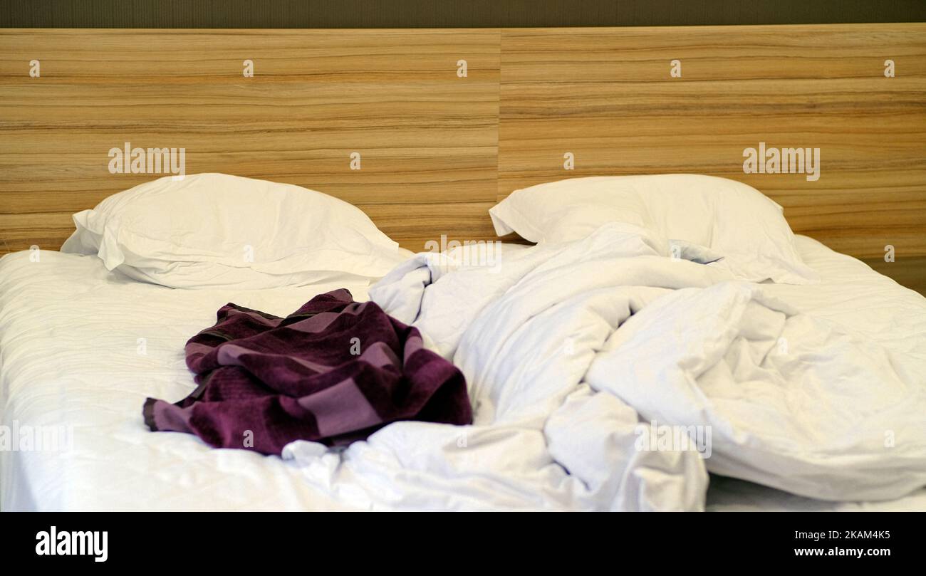 Bed with pillows and crumpled blanket. Crumpled blanket and pillows on