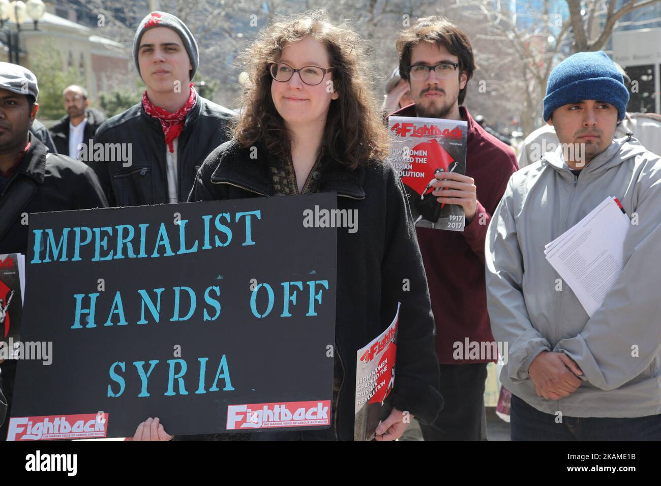 Woman holds a sign saying 'Imperialist Hands Off Syria' during a protest against US President Donald Trump's decision to launch airstrikes against Syria on April 8, 2017 in Toronto, Ontario Canada. Protestors gathered to outside the American Consulate in Toronto to denounce this week's airstrikes against the Syrian regime. America launched a missile strike against Syria for the first time since the civil war began, targeting an airbase in the small town of Idlib from which the United States claims this week’s chemical weapons attack on civilians was launched by Bashar al-Assad’s regime. (Photo Stock Photo