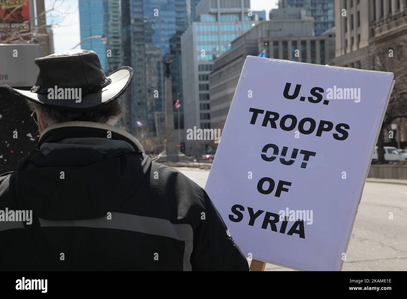Man holds a sign saying 'U.S. Troops out of Syria' during a protest against US President Donald Trump's decision to launch airstrikes against Syria on April 8, 2017 in Toronto, Ontario Canada. Protestors gathered to outside the American Consulate in Toronto to denounce this week's airstrikes against the Syrian regime. America launched a missile strike against Syria for the first time since the civil war began, targeting an airbase in the small town of Idlib from which the United States claims this week’s chemical weapons attack on civilians was launched by Bashar al-Assad’s regime. (Photo by C Stock Photo
