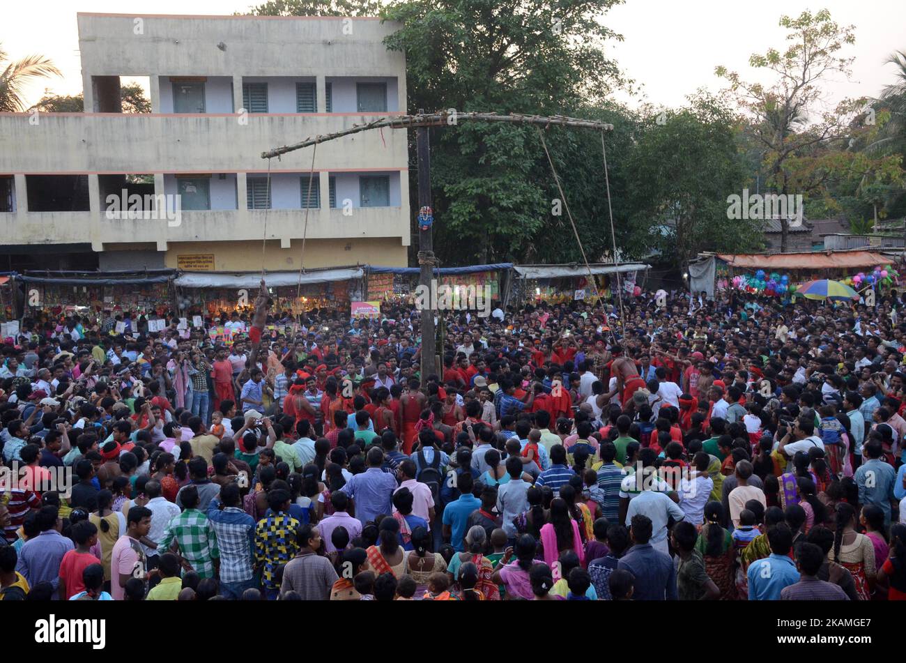 Indian Hindu devotee hanged from rope with iron hook during the Gajan