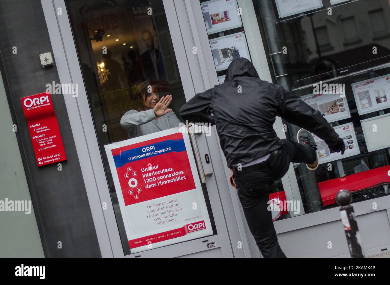 A protester kicks the window of a ORPI Office to destroy it during clashes between protesters and riot police on the edge of a demonstration for a 'social first round' of the French presidential election on April 22, 2017 on the place de la Republique in Paris. France was on edge on April 22 on the eve of its most unpredictable presidential election in decades, which will take place under heightened security after the jihadist killing of a policeman. (Photo by Julien Mattia/NurPhoto) *** Please Use Credit from Credit Field *** Stock Photo