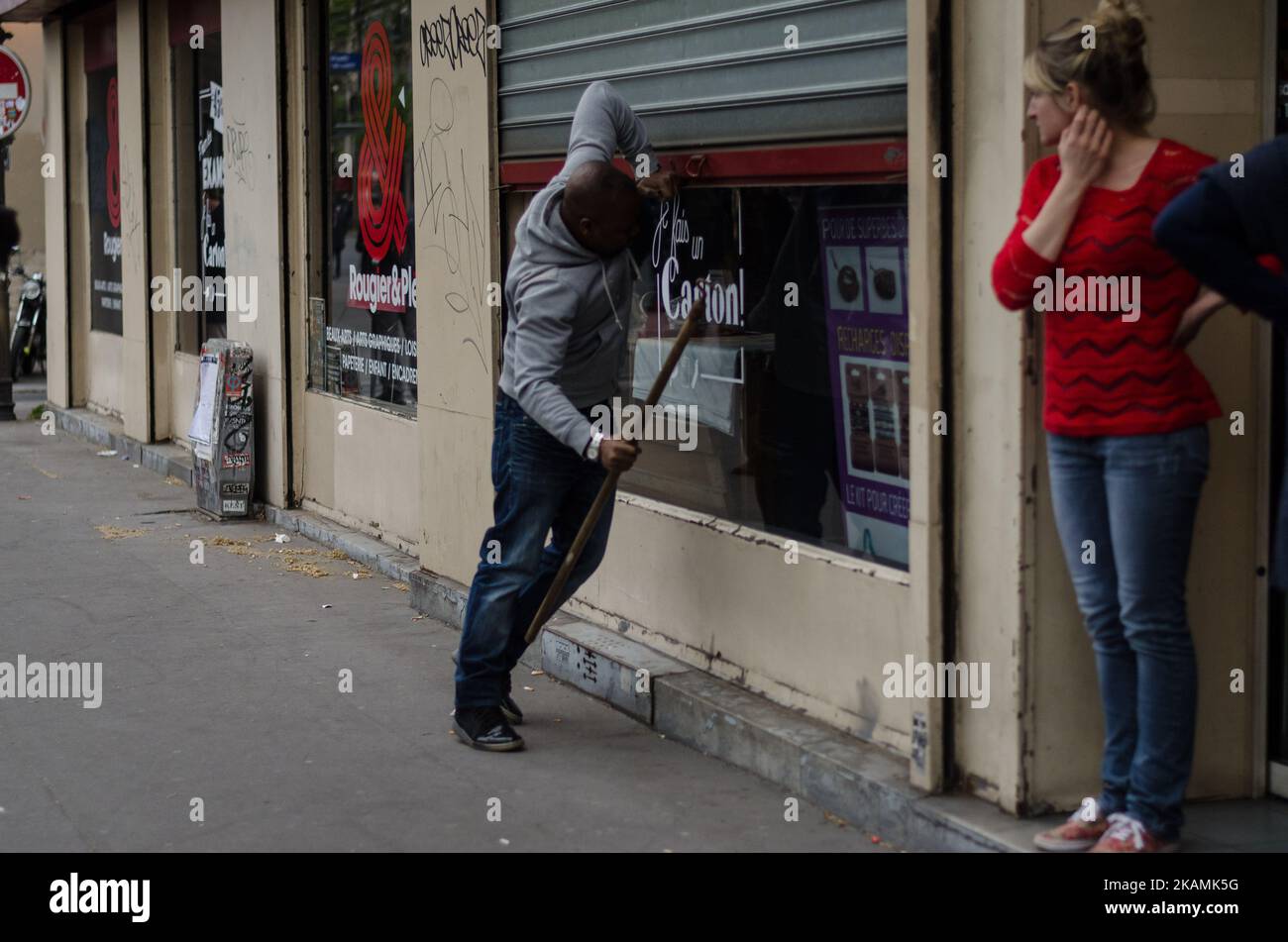A protester open the window of a Office to destroy it during clashes between protesters and riot police on the edge of a demonstration for a 'social first round' of the French presidential election on April 22, 2017 on the place de la Republique in Paris. France was on edge on April 22 on the eve of its most unpredictable presidential election in decades, which will take place under heightened security after the jihadist killing of a policeman. (Photo by Julien Mattia/NurPhoto) *** Please Use Credit from Credit Field *** Stock Photo