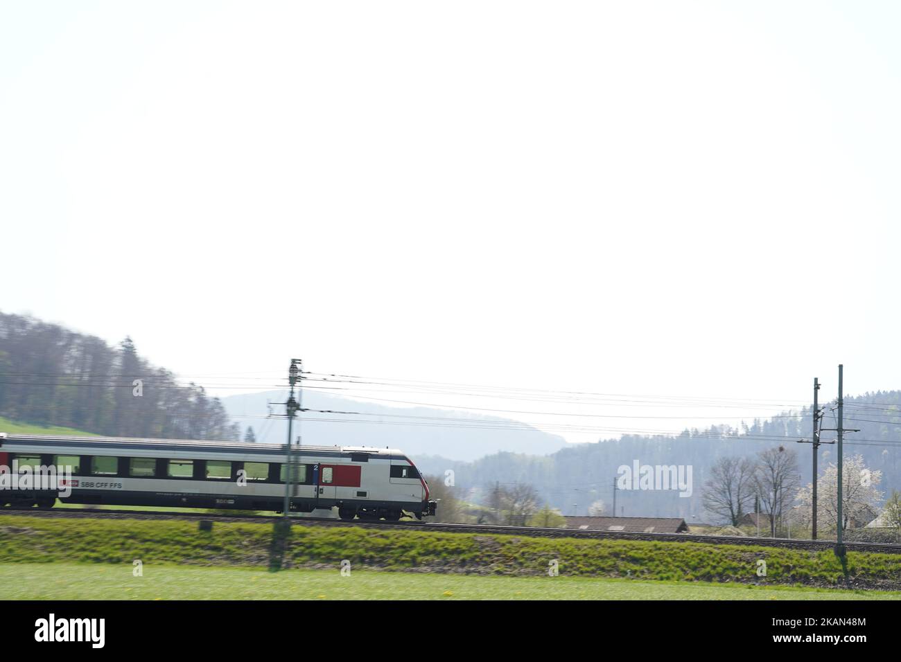 A SBB train driving through the field on the background of mountain forests, Sissach, Switzerland Stock Photo