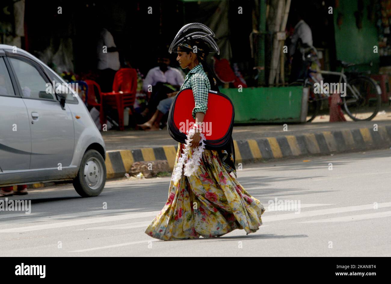 A nomadic woman holds Sun protective accessories and move in a traffic square to sale it to car drivers in a hot afternoon in the eastern Indian state Odisha's capital city Bhubaneswar, on May 24, 2017. (Photo by STR/NurPhoto) *** Please Use Credit from Credit Field *** Stock Photo