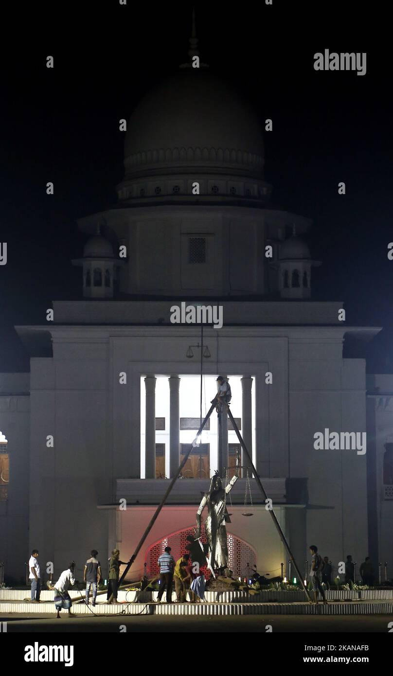 Bangladeshi workers take down a controversial statue of a sari-clad woman holding scales taken down amid tight security after months of protests by religious groups against what they called an un-Islamic Greek deity on May 26, 2017 in Dhaka. Bangladesh on May 26 removed a controversial statue depicting a goddess of justice outside its Supreme Court that religious hardliners had deemed un-Islamic, a move its creator said marked a victory for Islamists. (Photo by Sony Ramany/NurPhoto) *** Please Use Credit from Credit Field *** Stock Photo