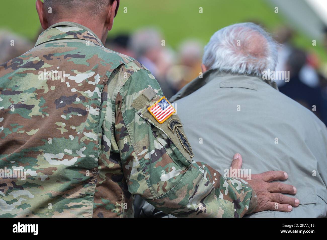 A member of the US Army helps a US DDay Veteran ahead of the