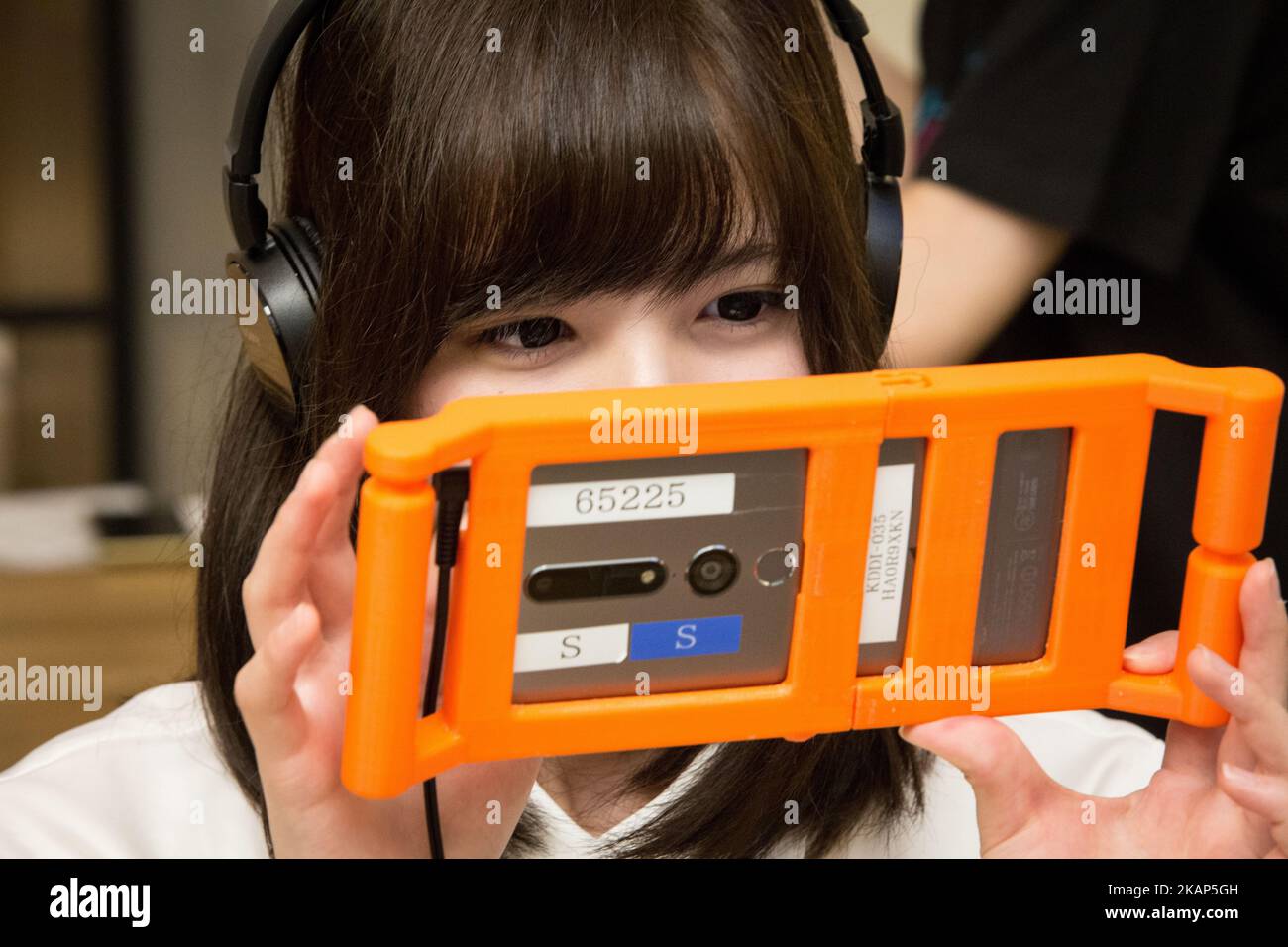 SENDAI, JAPAN - JULY 8: Anime fan holding a smart phone equipped with augmented reality (AR) application enjoying his virtual idol Hatsune Miku while having some sweets during an event in Sendai, Japan on July 8, 2017. As part of a promotion with telecommunications provider au/KDDI, Crypton Future Media and Blue Leaf Cafe operator, guest can enjoy dining with a special menu with their Vocaloid superstarIdol Hatsune Miku several days. (Photo by Richard Atrero de Guzman/NUR Photo) (Photo by Richard Atrero de Guzman/NurPhoto) *** Please Use Credit from Credit Field *** Stock Photo