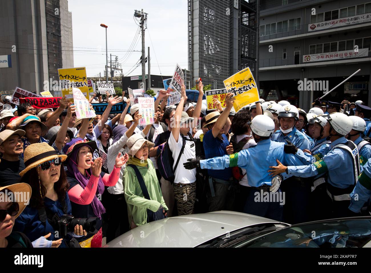 Anti-racist groups (L) tried to block Japanese nationalists from marching on the street during a counter-protest rally demanding an end to hate speech in Kawasaki City, Kanagawa prefecture, Japan on July 16, 2017. Scuffles erupted during a counter-protest on racism in Kawasaki City's Nakahara on Sunday, during a right-wing activists attempt to march with their slogans, flags, racist speech, forcing police to intervene. (Photo by Richard Atrero de Guzman/NUR Photo) *** Please Use Credit from Credit Field *** Stock Photo