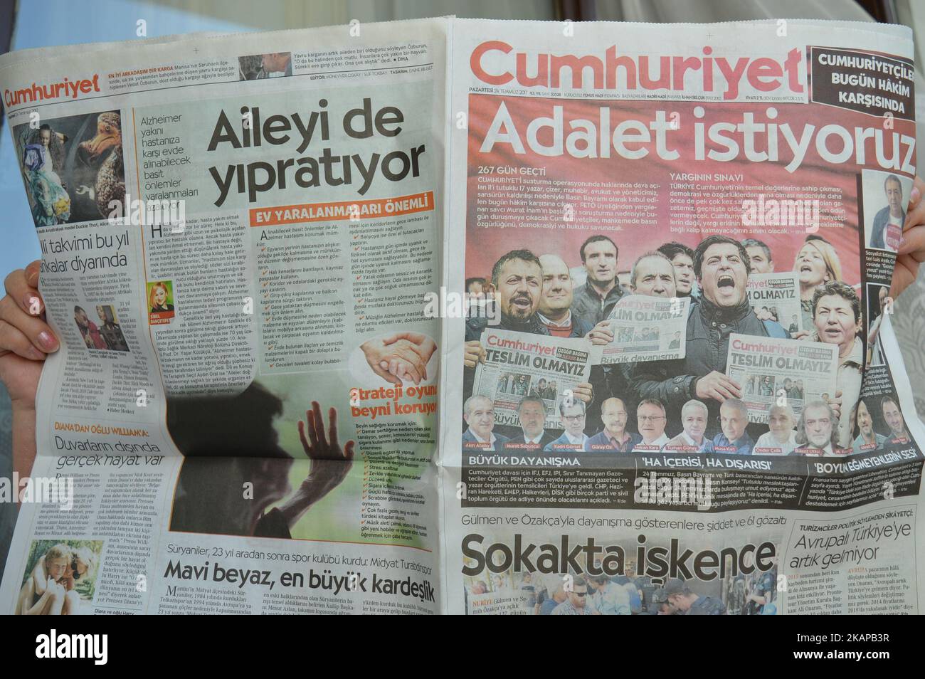 A person holds a copy of Turkish opposition daily newspaper Cumhuriyet ...
