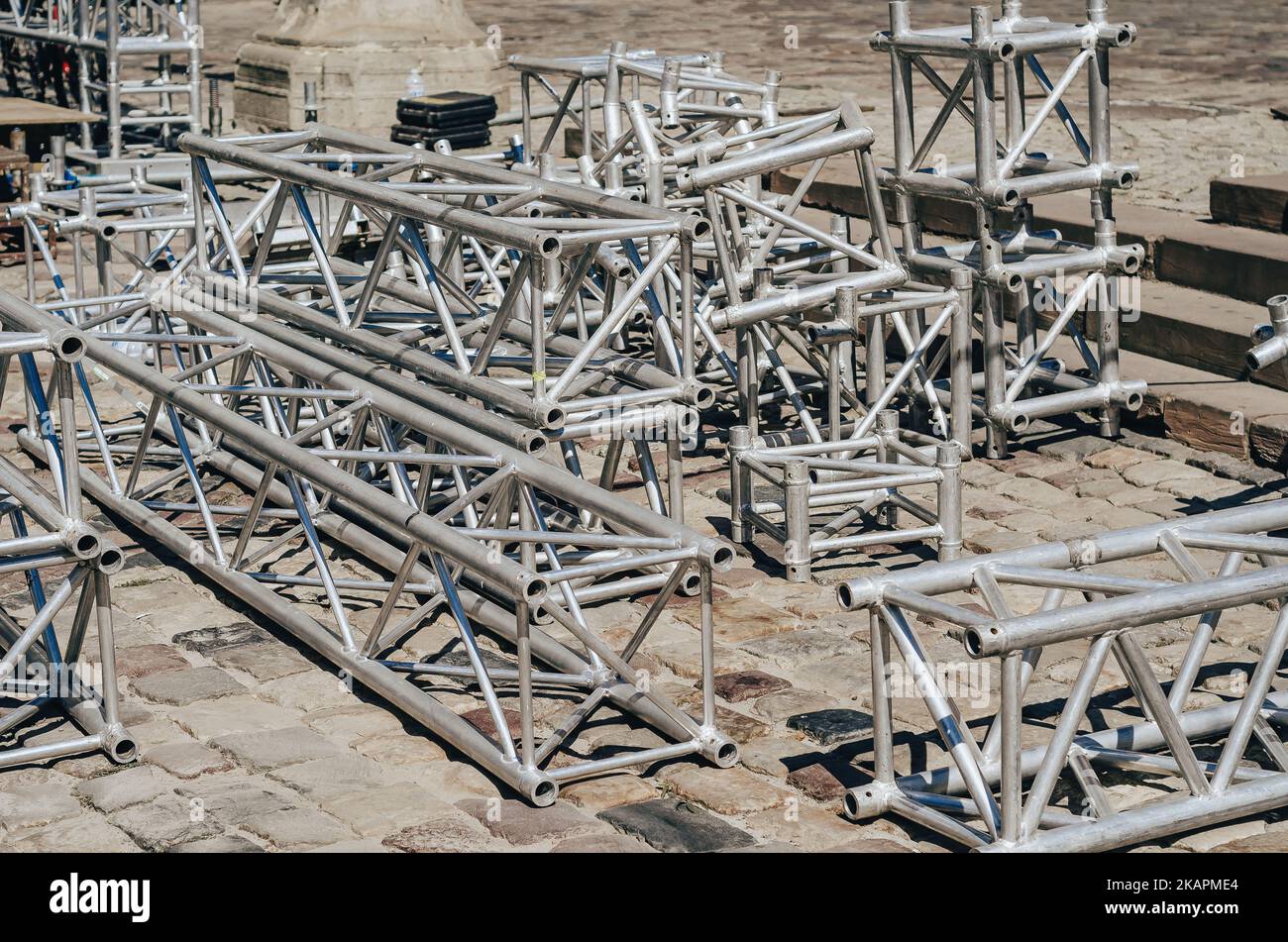 Metal trusses. Metal structures for stage installation lie on pavement. Stock Photo