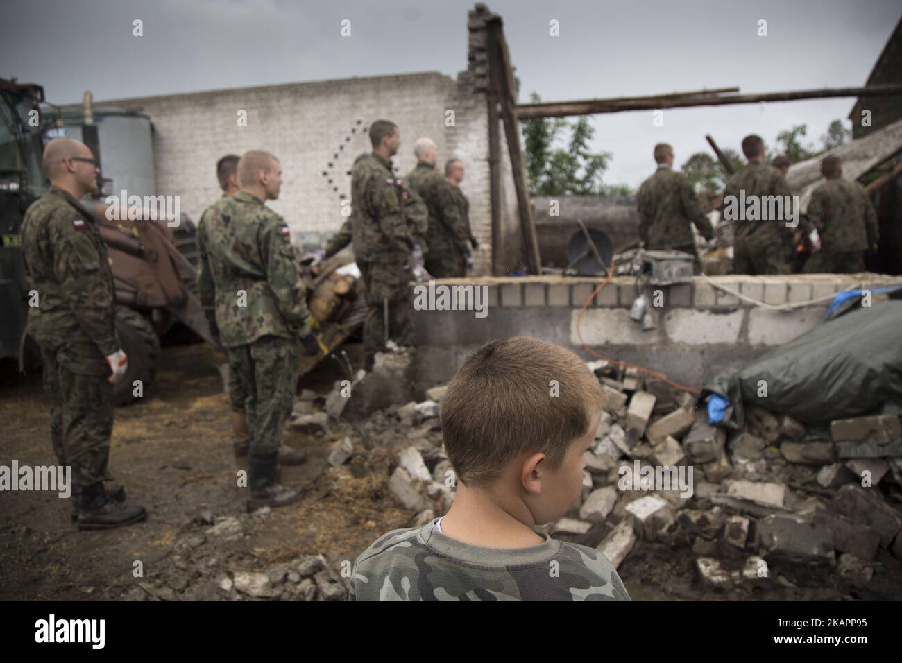 Boy stands near his family destroyed barn in Mala Klonia on August 23, 2017. (Photo by Maciej Luczniewski/NurPhoto) Stock Photo