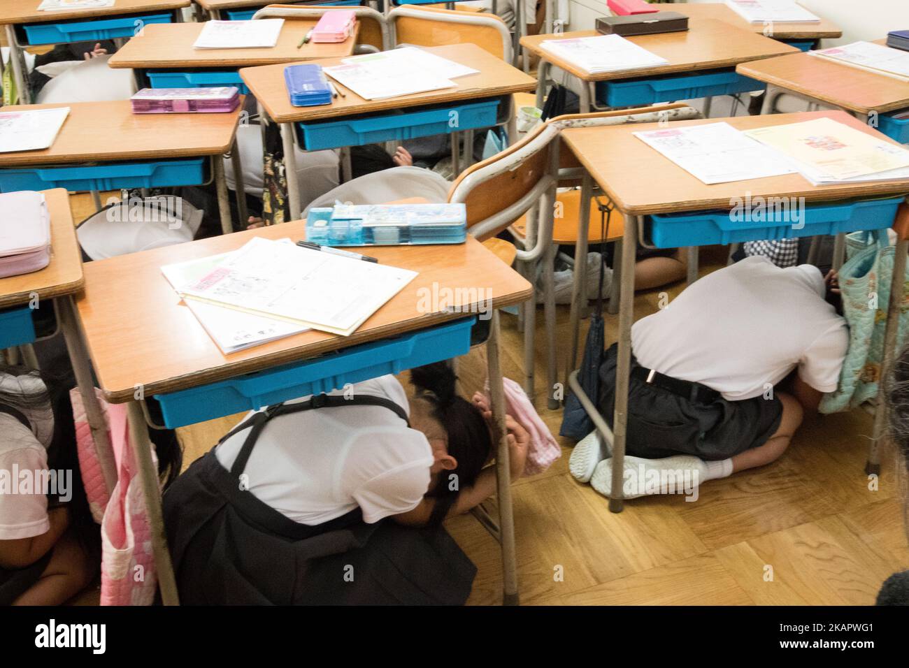 Elementary students cover under their desks during an evacuation drill in preparation for a North Korea'n ballistic missile attack that might happen anytime in Wajima, Ishikawa Prefecture, Japan on Aug. 30, 2017. North Korea launched a ballistic missile the previous day morning that flew over the sea of Japan. (Photo by Richard Atrero de Guzman/NurPhoto) Stock Photo