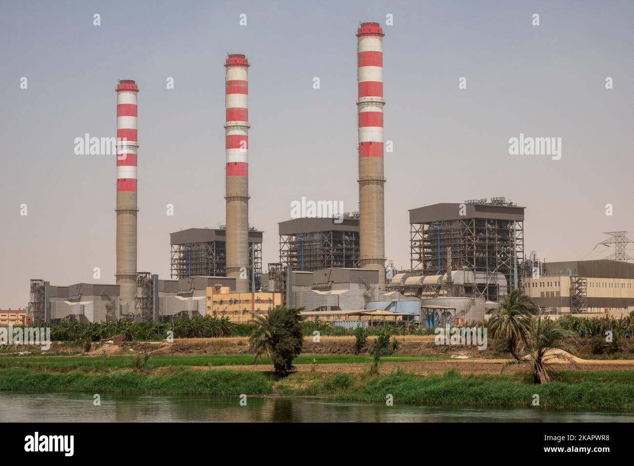 Three industrial chimneys on the banks of the river Nile, Egypt Stock Photo
