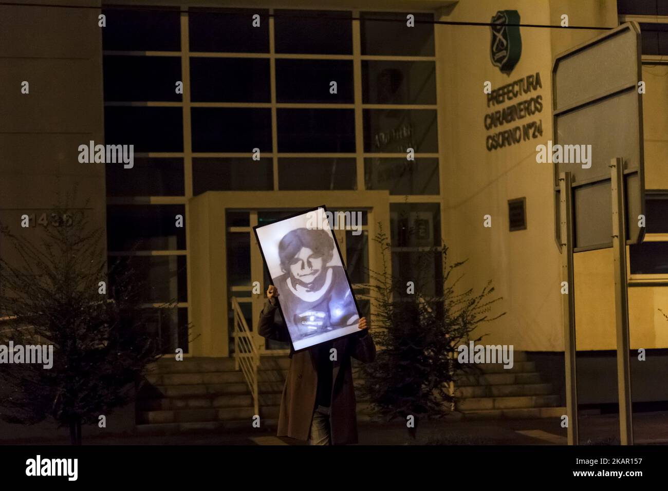 Osorno, Chile. 03 September 2017. Mapuche Huilliche visual artist Francisco Vargas Huaiquimilla walks in the city holding a plasma tv with the image and texts referring to the disappearance of the young man José Huenante. José Gerardo Huenante Huenante, a 16-year-old boy, was arrested and made to disappear by the Chilean police on September 3, 2005 in the city of Puerto Montt in southern Chile. José disappears during the government of the Concertación chaired by Ricardo Lagos. He is the second detainee disappeared in civilian governments. The body has not yet been found 12 years after his arre Stock Photo